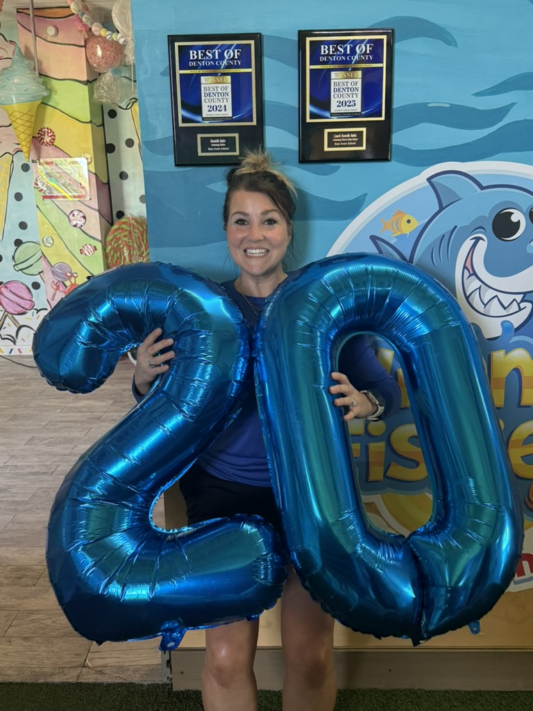 Coach Danielle holding 20-year balloons at Swimming Fishies Swim School