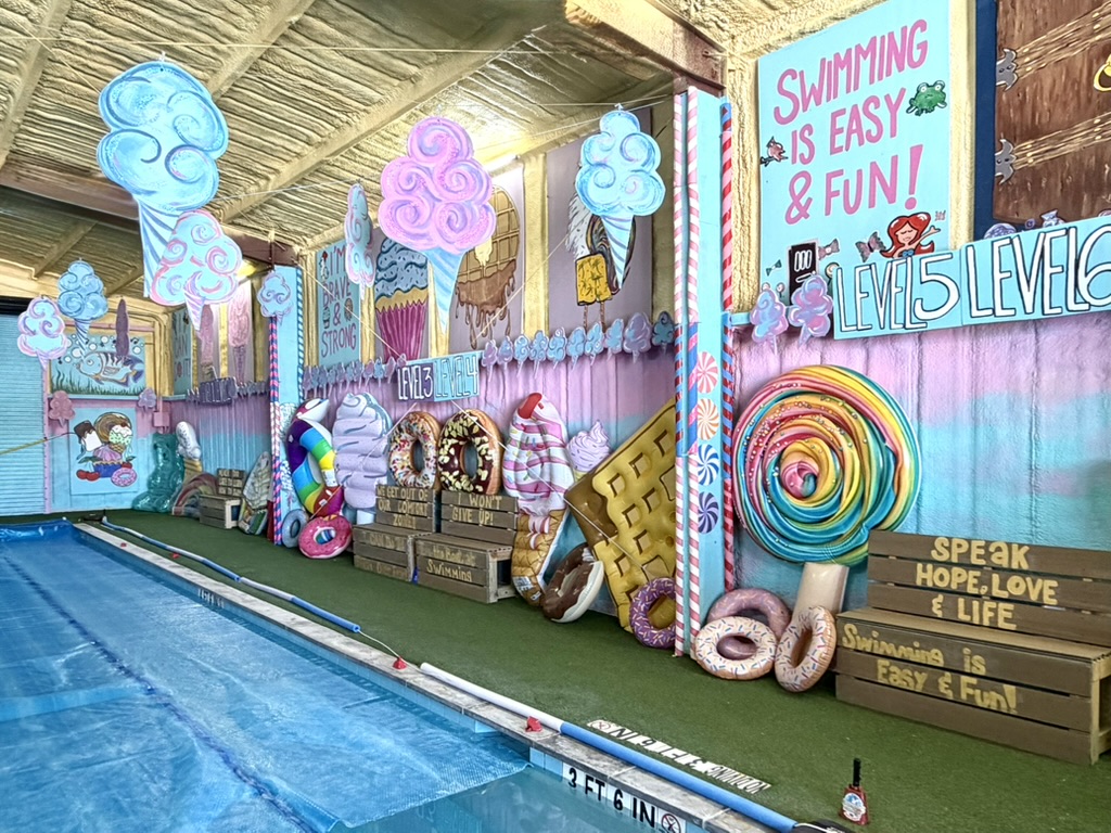 Candy-themed murals and decorations along the indoor pool